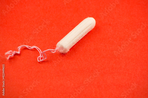 tampon for personal hygiene on a red background 