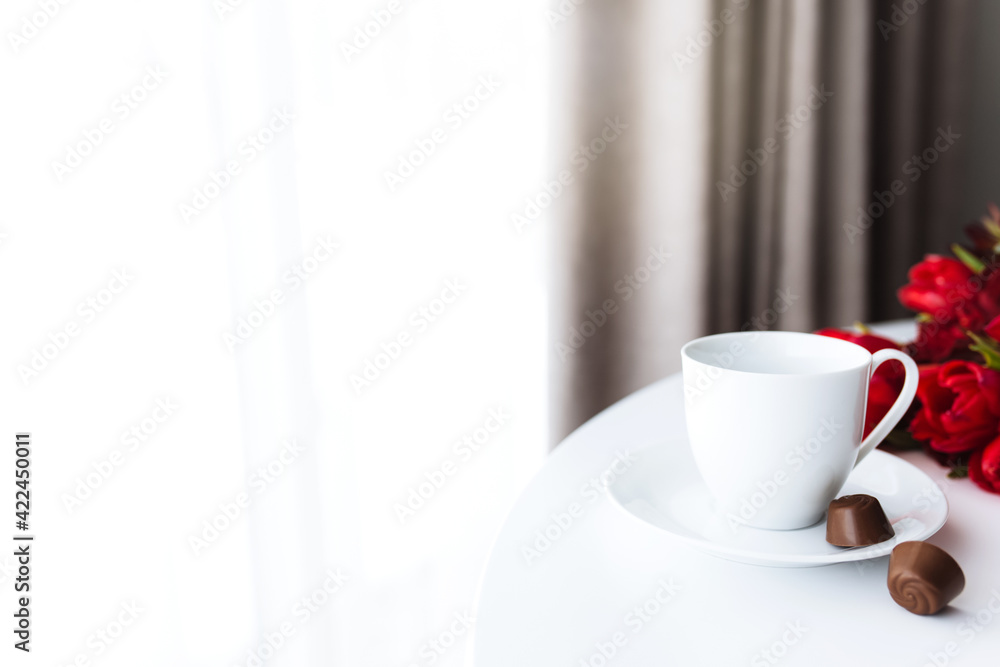 Bouquet of red tulips on table and white coffee cup. Concept for greeting card Bouquet of red tulips on table and white coffee cup. Concept for greeting card