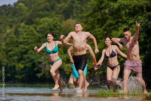 group of happy friends having fun on river