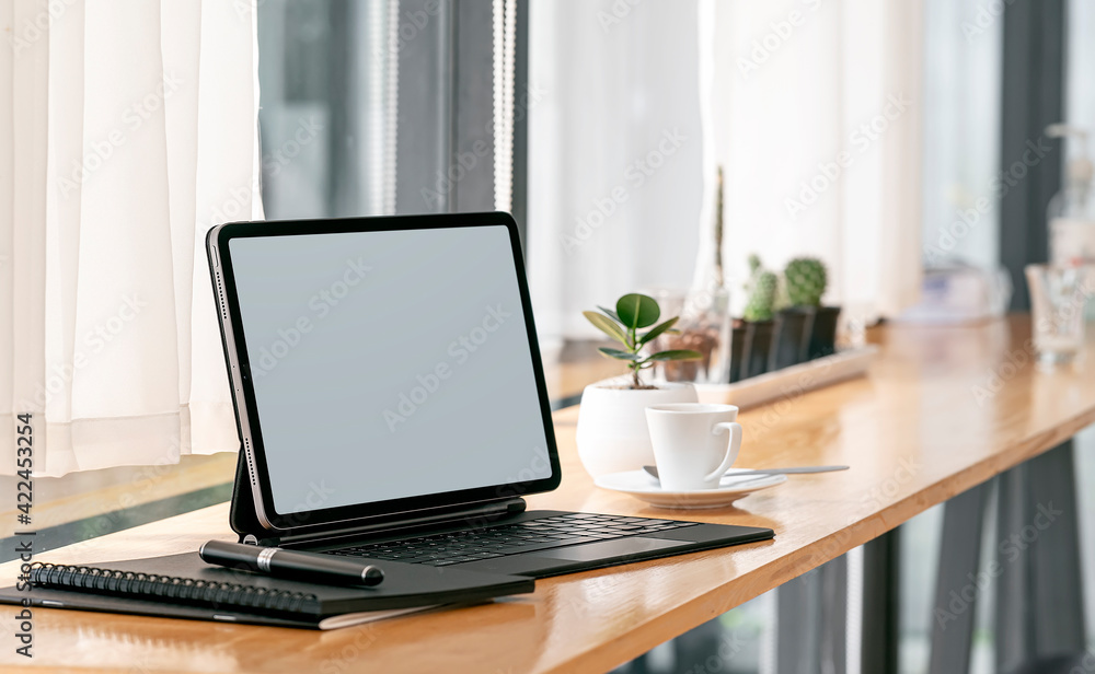 Mockup blank screen tablet with keyboard on wooden counter table in cafe. Mockup blank screen tablet with keyboard on wooden counter table in cafe.