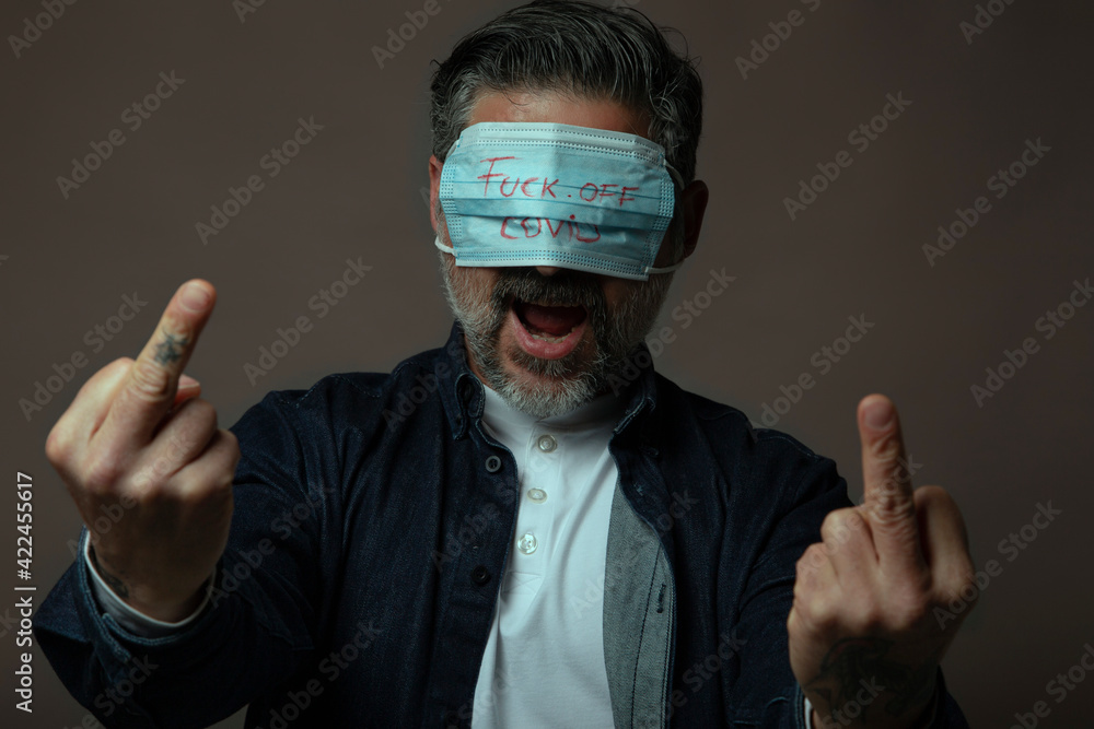 Angry man with eye mask showing middle finger gesture in protest. Angry man with eye mask showing middle finger gesture in protest.
