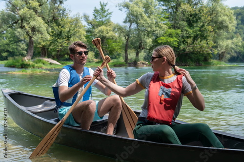 friends are canoeing in a wild river