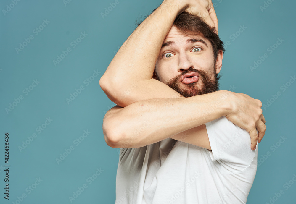 Emotional man on a blue background gestures with his hands surprise model delight Emotional man on a blue background gestures with his hands surprise model delight