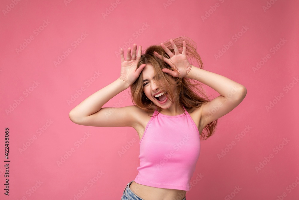 Crazy young attractive blonde woman with sincere emotions isolated on background wall with copy space wearing stylish pink top. Positive concept Crazy young attractive blonde woman with sincere emotions isolated on background wall with copy space wearing stylish pink top. Positive concept