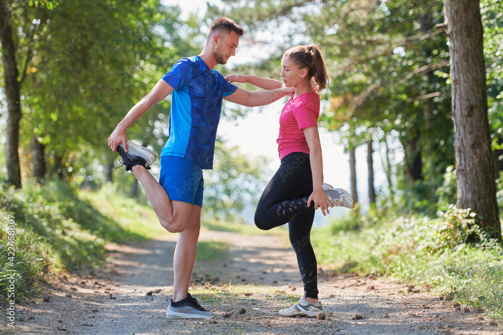 couple enjoying in a healthy lifestyle warming up and stretching before jogging couple enjoying in a healthy lifestyle warming up and stretching before jogging