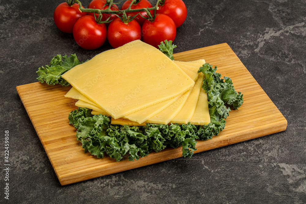 Sliced Gauda cheese over board Sliced Gauda cheese over board