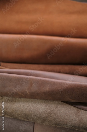 Leather brown rolls.Leatherworking.Leather goods material. Genuine leather set of brown colors.Hobby and craft material.Leather brown pieces assortment.
