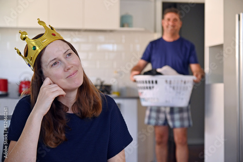 Happy adult woman wearing queens crown daydreaming