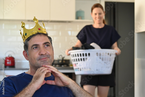 Mature adult man wearing kings crown daydreaming