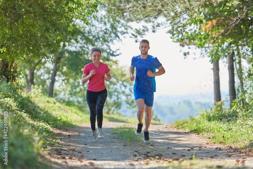 couple enjoying in a healthy lifestyle while jogging on a country road