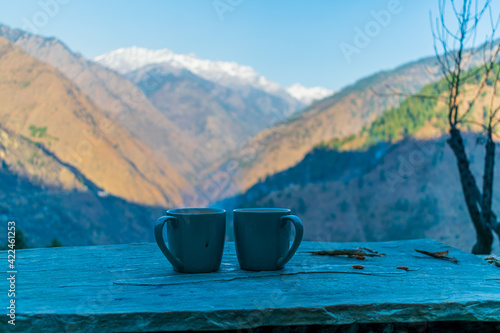 Two cups of coffee and the snow capped mountain range, Pekhri, Himachal Pradesh, India