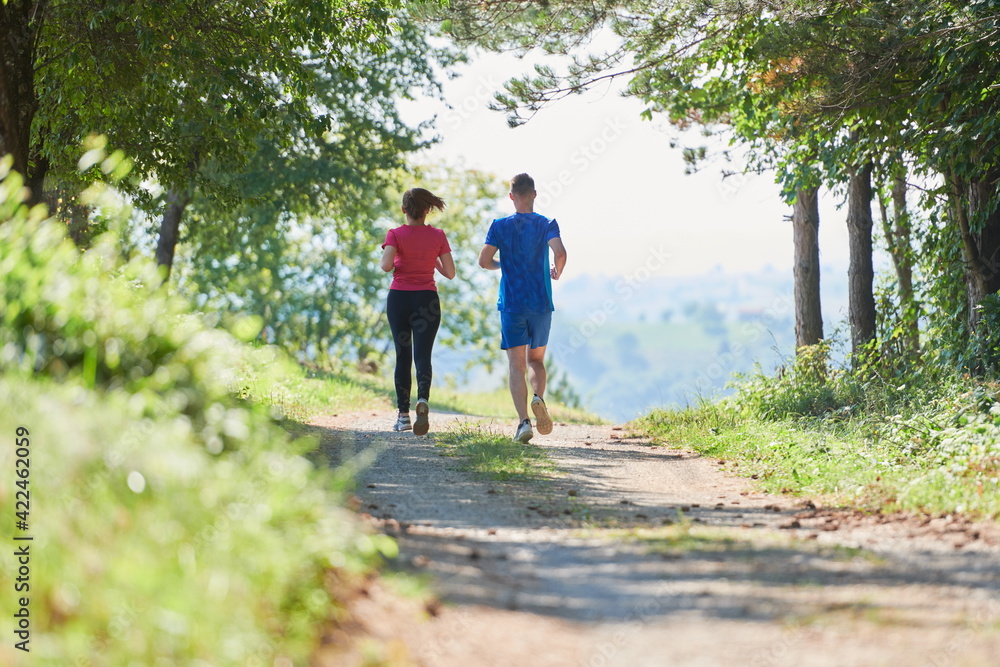 couple enjoying in a healthy lifestyle while jogging on a country road couple enjoying in a healthy lifestyle while jogging on a country road