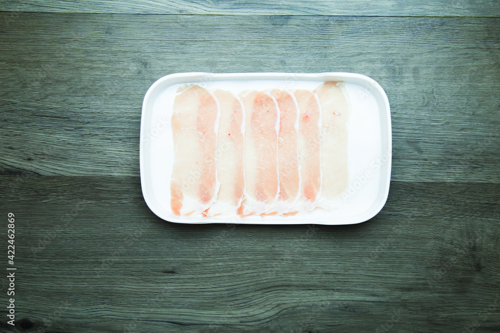 Obraz premium fresh raw pork, meat ,beef, belly, sliced on square plate on wood, wooden background,set shabu, hot pot ingredients.