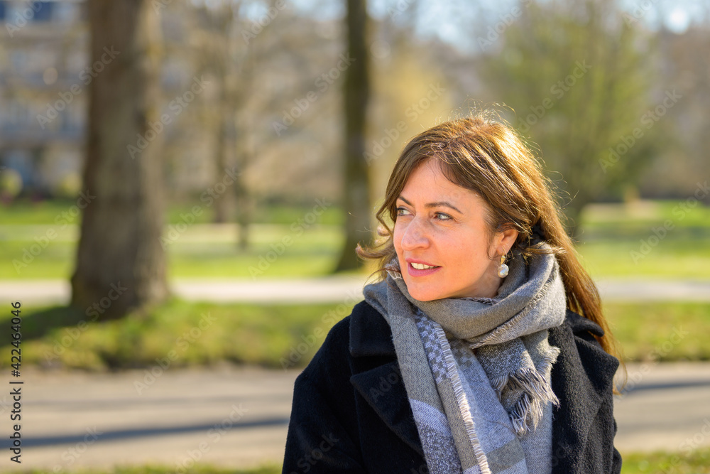 Attractive fashionable woman relaxing on a park bench in spring Attractive fashionable woman relaxing on a park bench in spring