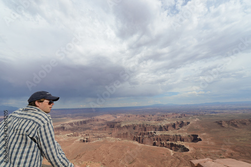 Scenic view of a man enjoying the scenery from the rim of Canyonlands National Park on a cloudy day © Jen