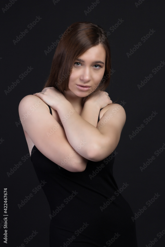 Young brown-haired woman, studio photo on a black background Young brown-haired woman, studio photo on a black background