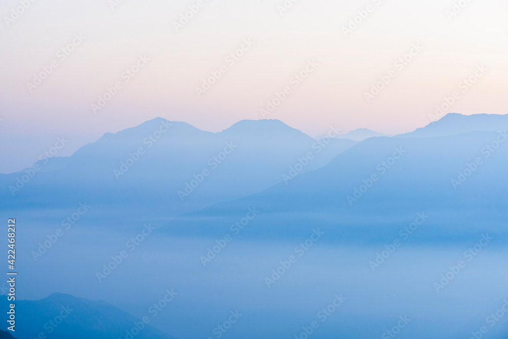 Layers of magnificent mountains with colorful clouds background at sunrise view Layers of magnificent mountains with colorful clouds background at sunrise view