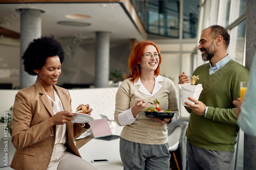 Canvas Print Group of happy business people eating lunch and enjoying in conversation on a break at work