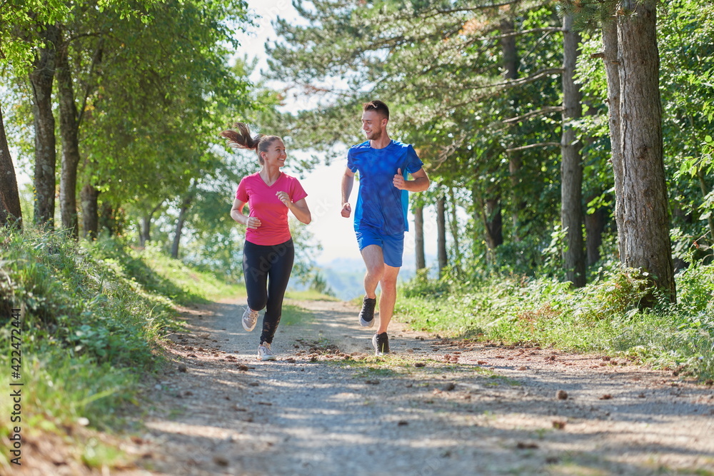 couple enjoying in a healthy lifestyle while jogging on a country road couple enjoying in a healthy lifestyle while jogging on a country road