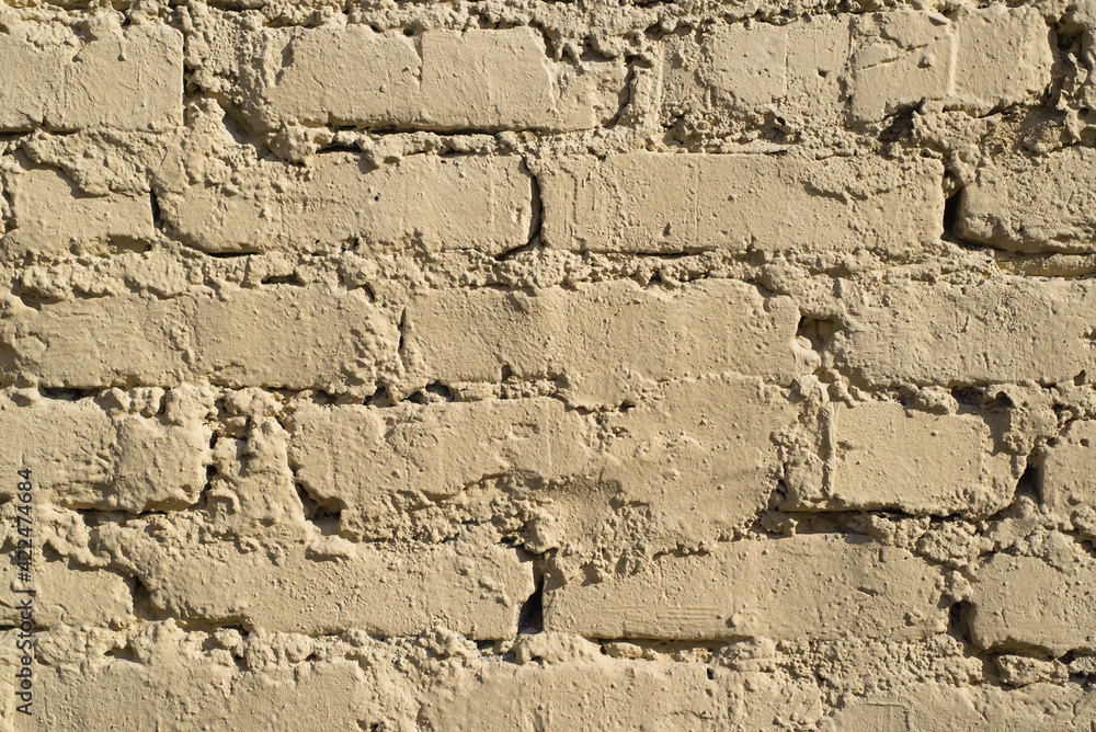 Textured rough wall of yellow bricks outside. Uneven masonry Textured rough wall of yellow bricks outside. Uneven masonry
