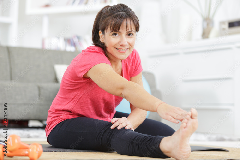 woman in sportswear doing simple morning exercises at home woman in sportswear doing simple morning exercises at home