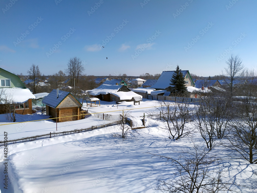 Summer cottages in the snow. Snow covered vegetable garden in the countryside. View from above. Snowy winter landscape.