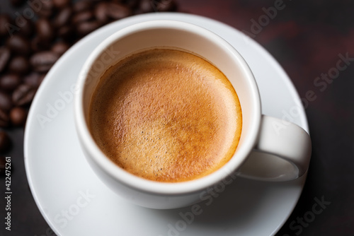 White cup of coffee and coffee bean on dark background. Copy space.close up  view.
