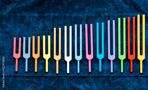 Konstfotografi set of colorful metal tuning forks, sound healing and acutonic tools in order of