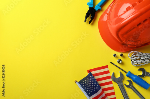 Concept of Happy Labor Day with different accessories on yellow background photo