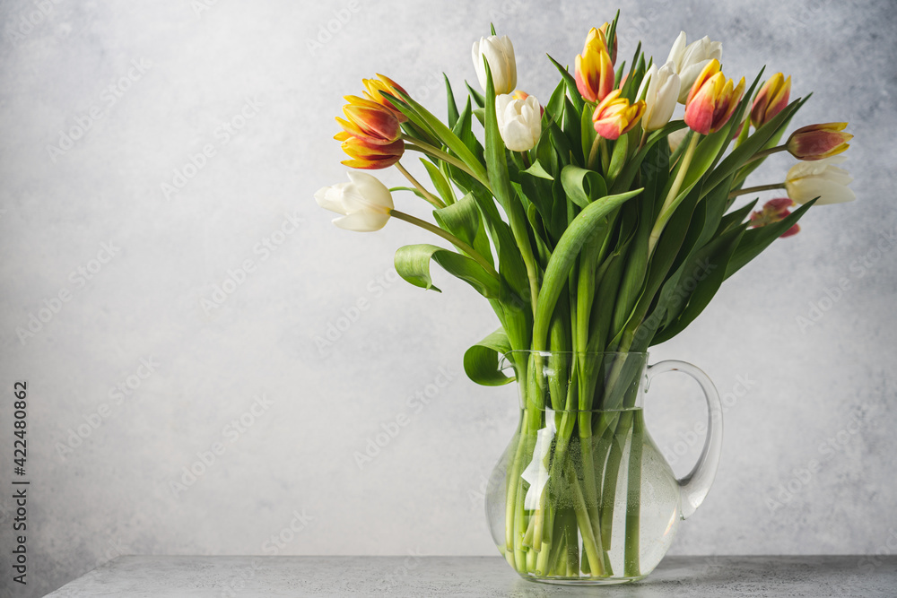 Bouquet of tulips in glass jur on gray background. Easter and spring greeting card Bouquet of tulips in glass jur on gray background. Easter and spring greeting card
