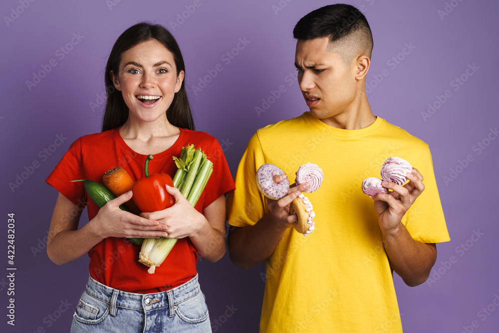 Brunette white couple posing with vegetables and cakes Brunette white couple posing with vegetables and cakes