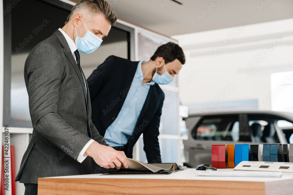 Mid unshaven manager working with mature customer in car showroom Mid unshaven manager working with mature customer in car showroom