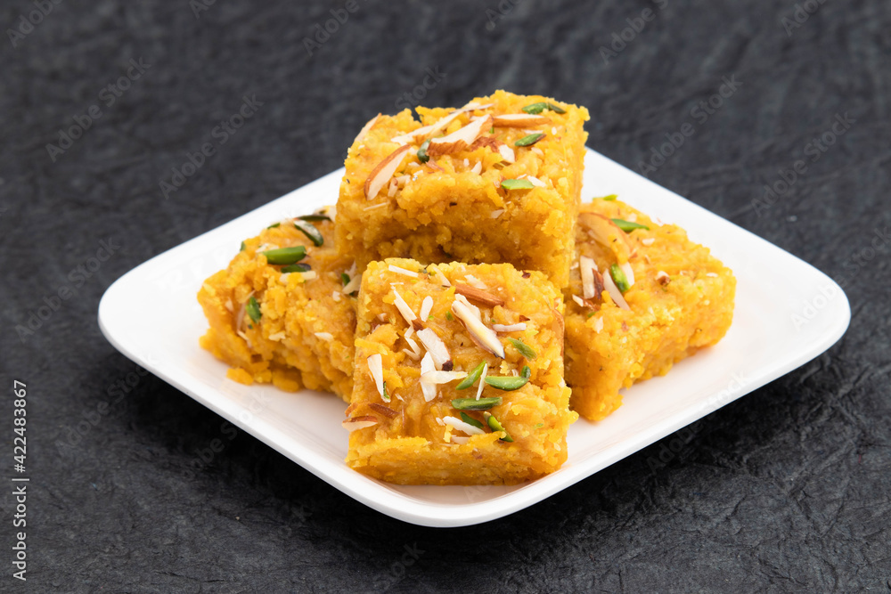 Sindhi Indian Mithai Sev Badam Halwa Burfi Barfee Or Barfi Is Made Of Bengal Gram Flour Besan Kaju Kesar Pista Khoya Meetha Doodh Mawa Malai In Desi Ghee. Isolated On Black Background With Copy Space Sindhi Indian Mithai Sev Badam Halwa Burfi Barfee Or Barfi Is Made Of Bengal Gram Flour Besan Kaju Kesar Pista Khoya Meetha Doodh Mawa Malai In Desi Ghee. Isolated On Black Background With Copy Space