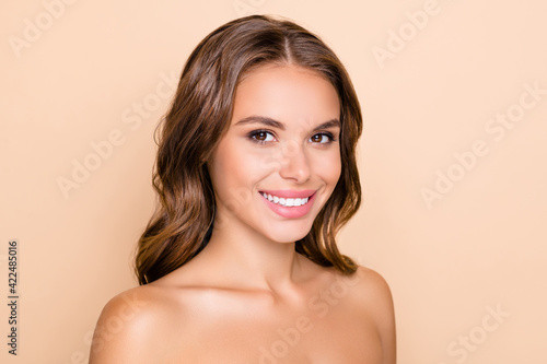 Photo of nice optimistic lady without clothes look to camera isolated on pastel beige color background