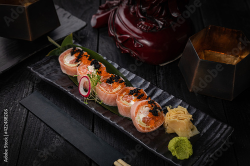 Japanese rolls on a dark plate in a restaurant 
