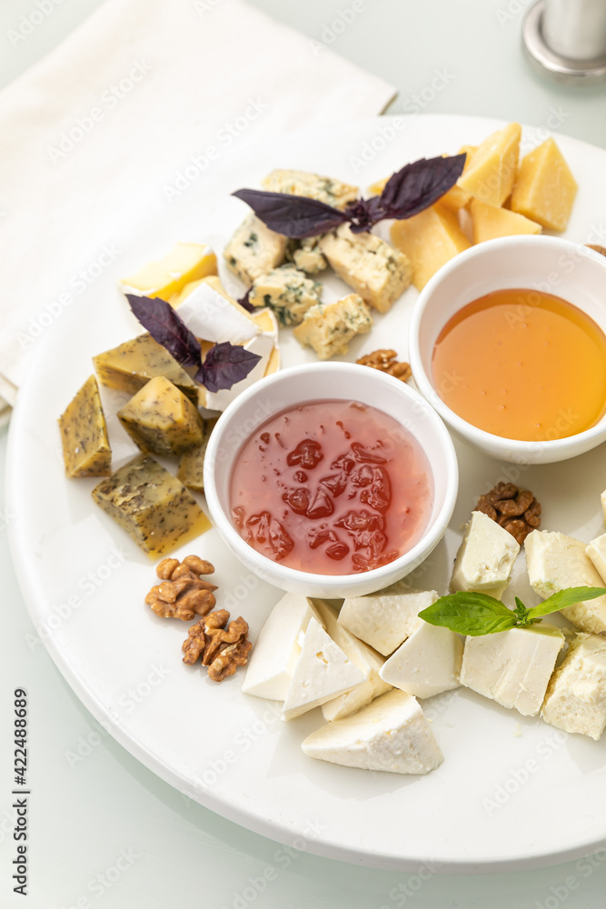 Plate with assorted cheeses and honey
