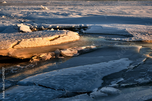 blocks of ice on the snow under the evening sun