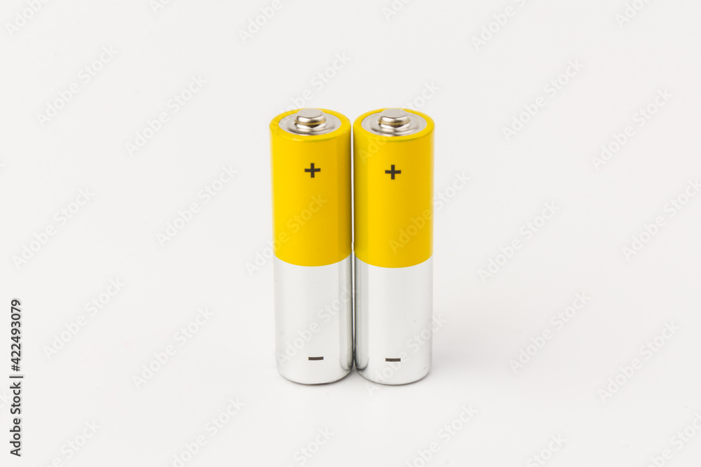 Photo of gray-yellow alkaline AA batteries on white background. Recycling of rechargeable NiMH batteries. The most popular size of accumulators. Copy space. Photo of gray-yellow alkaline AA batteries on white background. Recycling of rechargeable NiMH batteries. The most popular size of accumulators. Copy space.