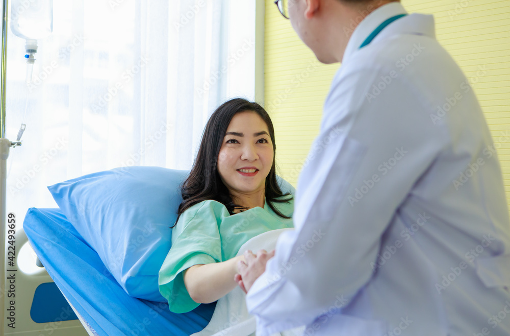 Female patient on sofa in hospital watching clipboard with doctor Female patient on sofa in hospital watching clipboard with doctor