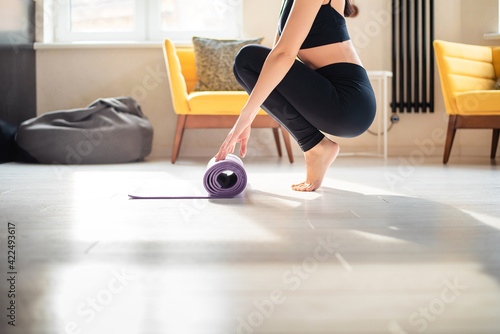 Close up of woman preparing yoga mat for training at home