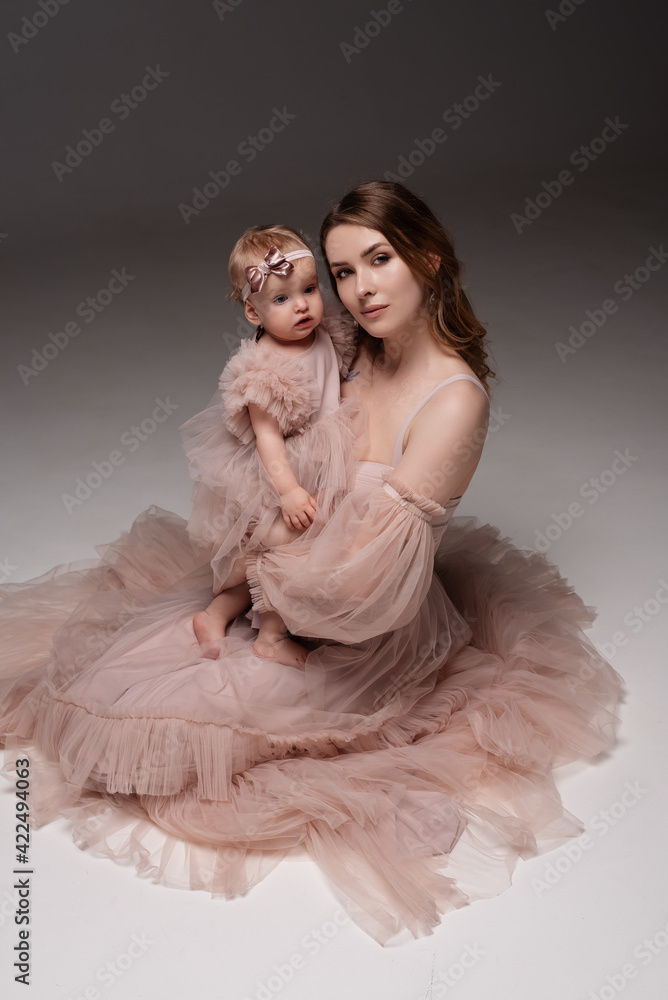 Woman in light clothes have fun with cute child baby girl 1 years old. Mommy little kid daughter isolated on grey background studio portrait. Mother's Day love family parenthood childhood concept