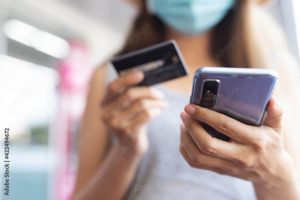 Close up image.A woman using smart phone for shopping online with credit card at coffee cafe.Online payment concept.