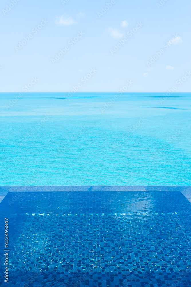 Beautiful private infinity outdoor swimming pool with sea ocean white cloud and blue sky view