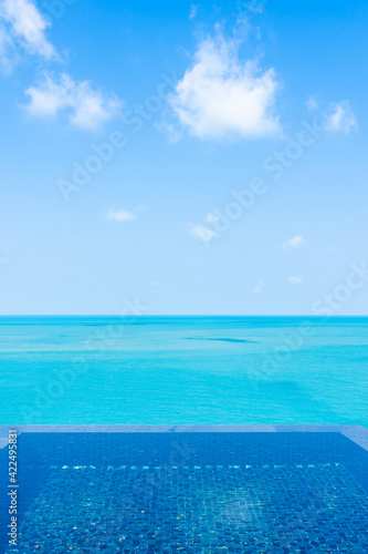 Beautiful private infinity outdoor swimming pool with sea ocean white cloud and blue sky view