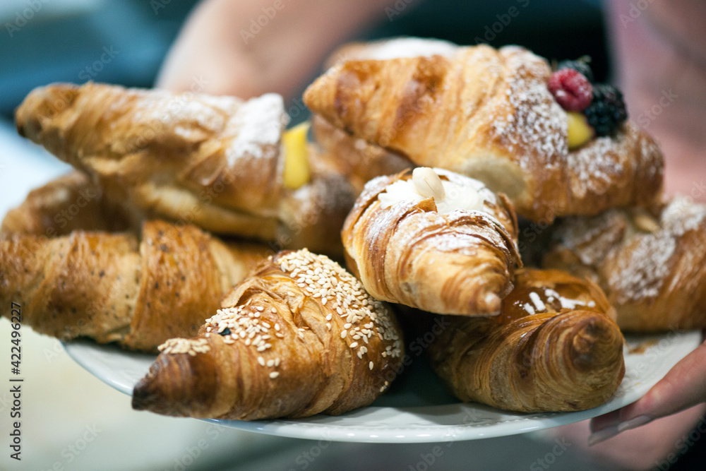 Freshly baked croissants on a plate with different fillings.