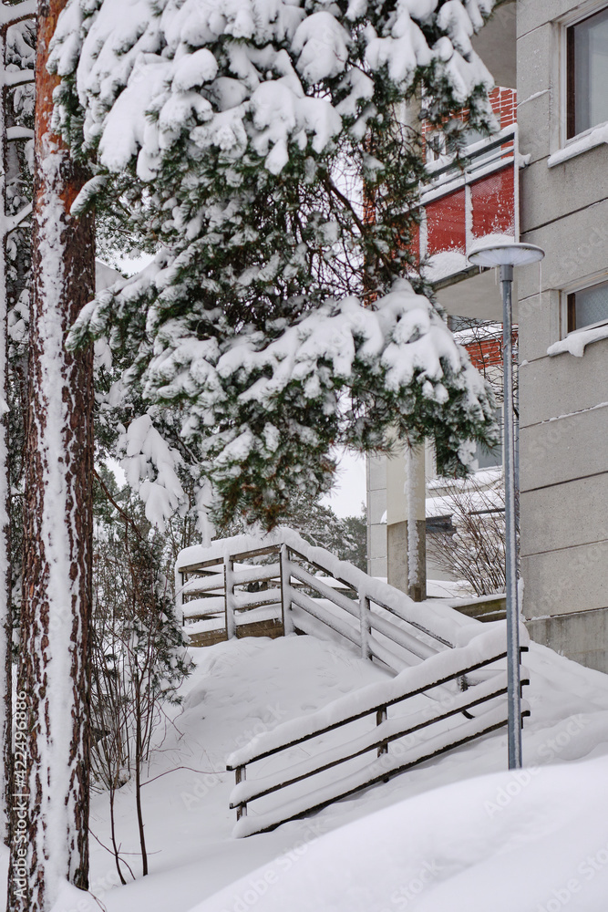 The snow-covered yard of the residential apartment building after a strong snow-storm in Finland.