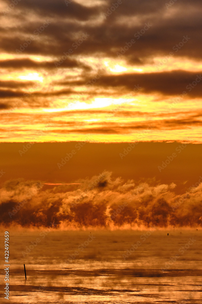 Fog over the Baltic sea during a strong frost in the sunset.