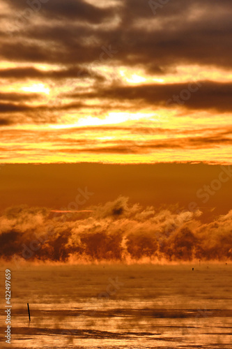 Obraz na płótnie Fog over the Baltic sea during a strong frost in the sunset. w salonie