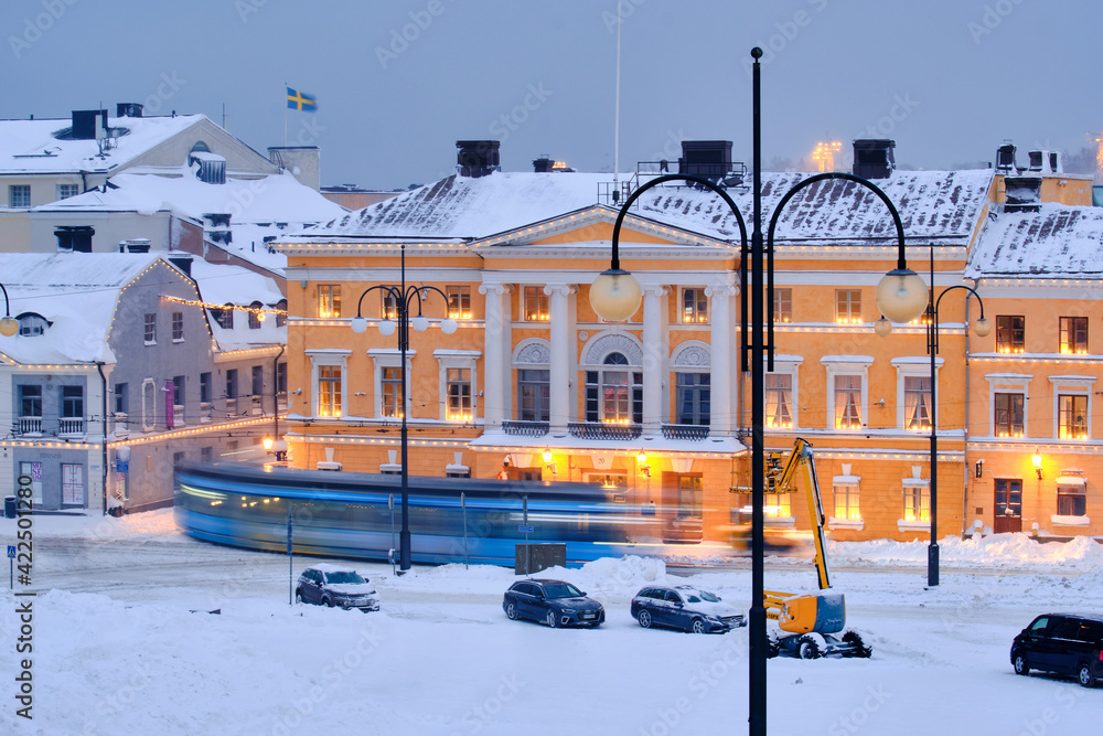 Helsinki, Finland - January 13, 2021: The tram is moving on the Senate Square during the strong snowstorm.