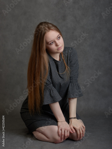 Young long-hared woman sitting on her knees